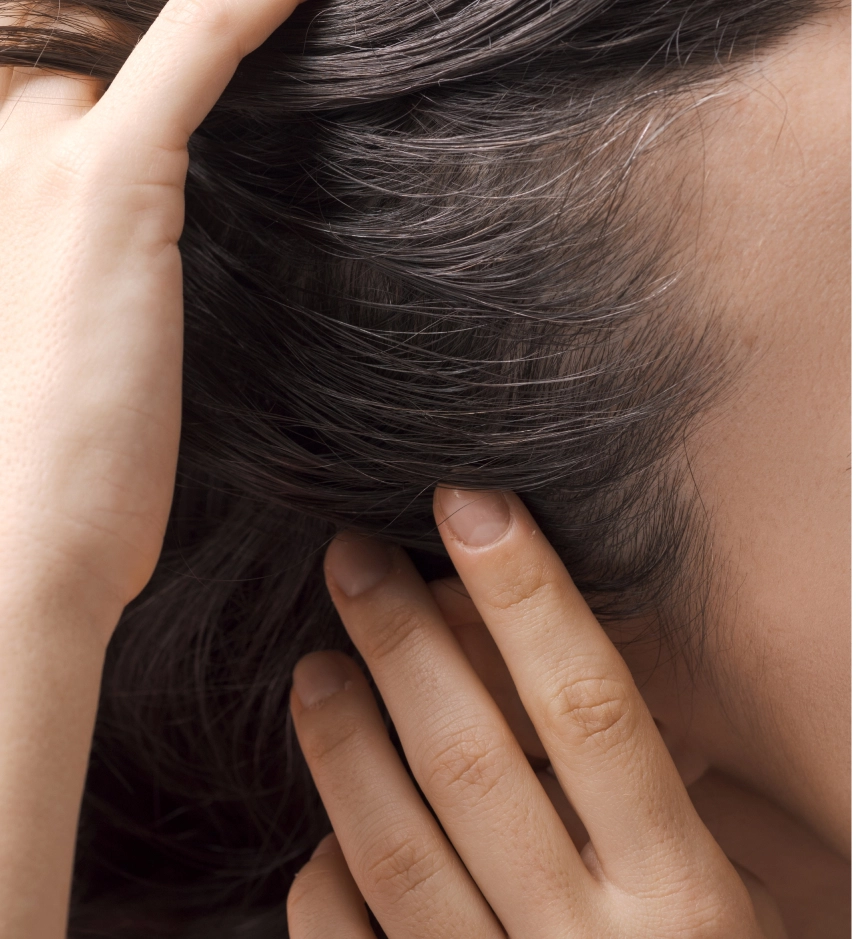 Close-up of person's hands touching healthy dark hair and skin